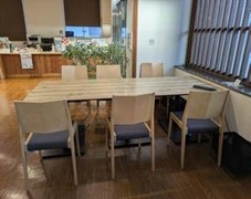 長方形のテーブルがあり、両側に3脚ずつ椅子が置かれている6人用テーブルの写真