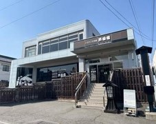玄関へと続く階段があり、玄関前には青い暖簾がかかっているふるさと交流館の外観写真
