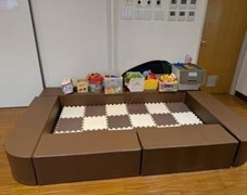 ベージュや、茶色のマットが敷かれたキッズスペースの写真