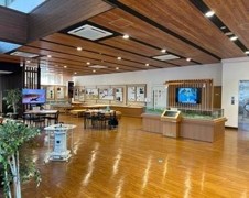 木を基調とした室内で、カウンターやテレビモニター、ジオラマ、テーブル席などがある立科町ふるさと交流館の写真