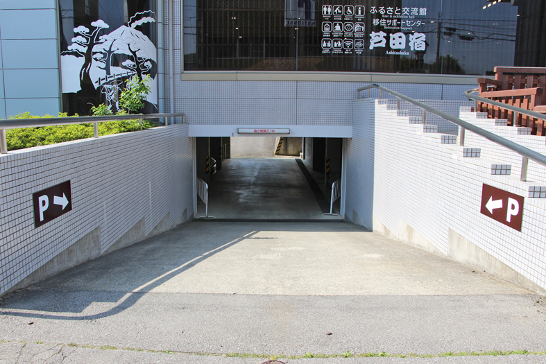 建物の下へスロープが伸びている地下駐車場入り口の写真
