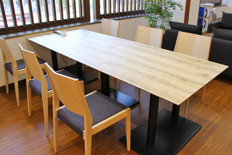 長方形のテーブルがあり、両側に3脚ずつ椅子が置かれている6人用テーブルの写真