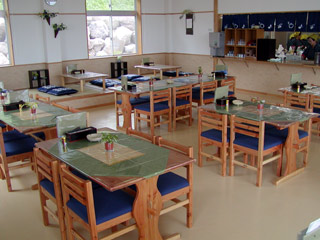 奥に座敷、手前に4人掛けのテーブル席が並んでいる食材供給施設の写真
