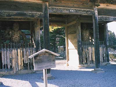 古い木造の門の左右の囲まれた場所に2体の仁王像が安置されてる写真
