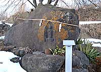 大きな石に観音像が刻まれ、紙垂の下がったしめ縄が掛けられている観音坂のおさんやさまの写真
