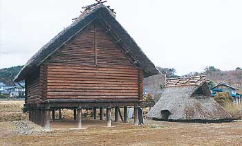 木材で組み立てられた高床式倉庫と藁葺き屋根が並んで展示されている大庭遺跡の写真